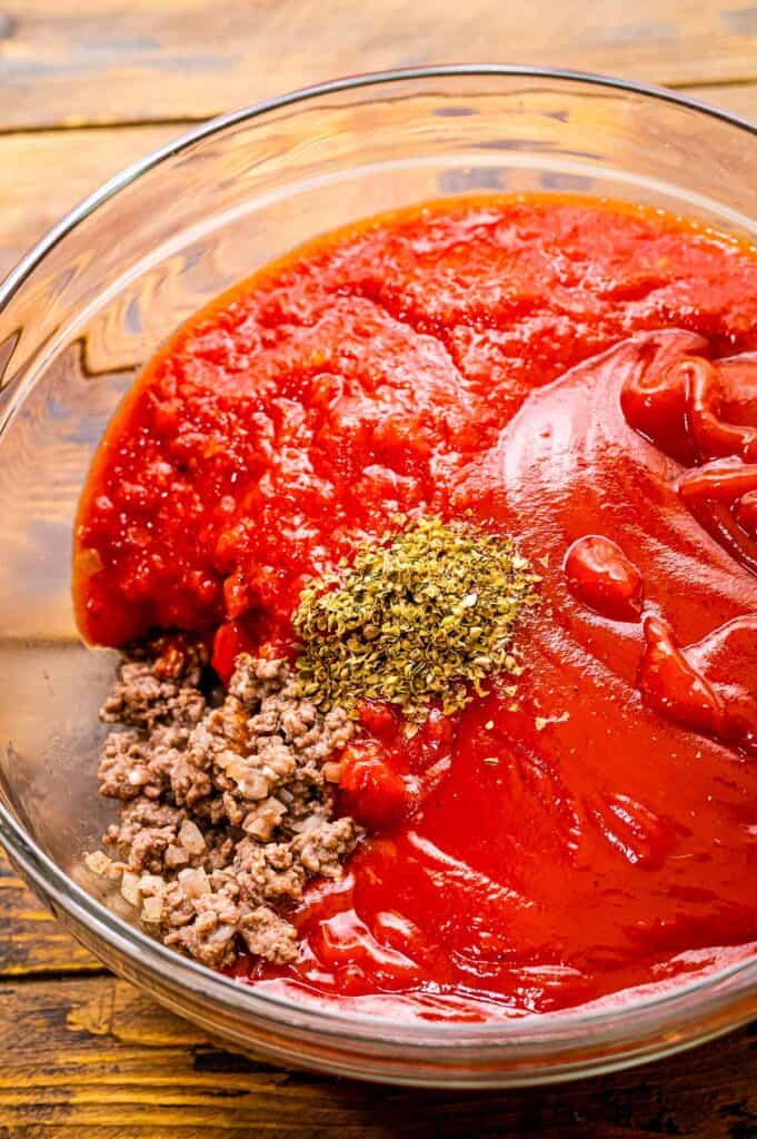 Glass bowl with tomato sauce, ground beef and seasonings