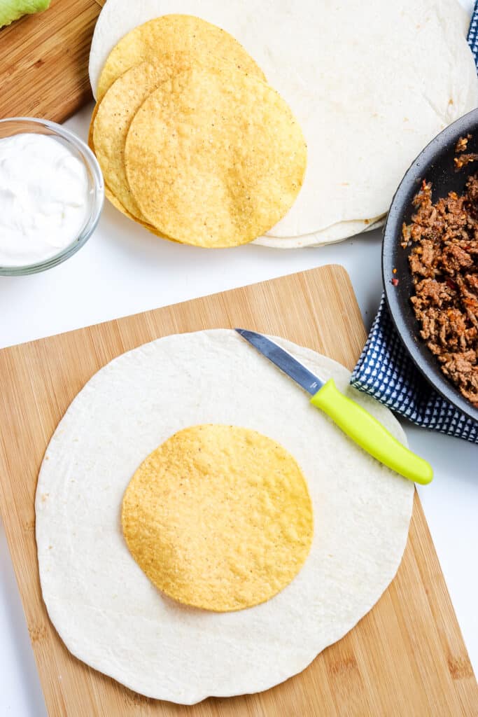 Tostada laying on top of flour tortilla