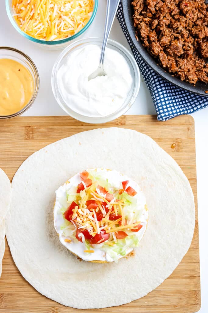 Softshell topped with ingredients for crunchwrap supreme.