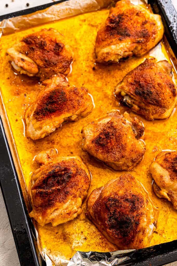 Sheet pan with seasoned and baked chicken thighs