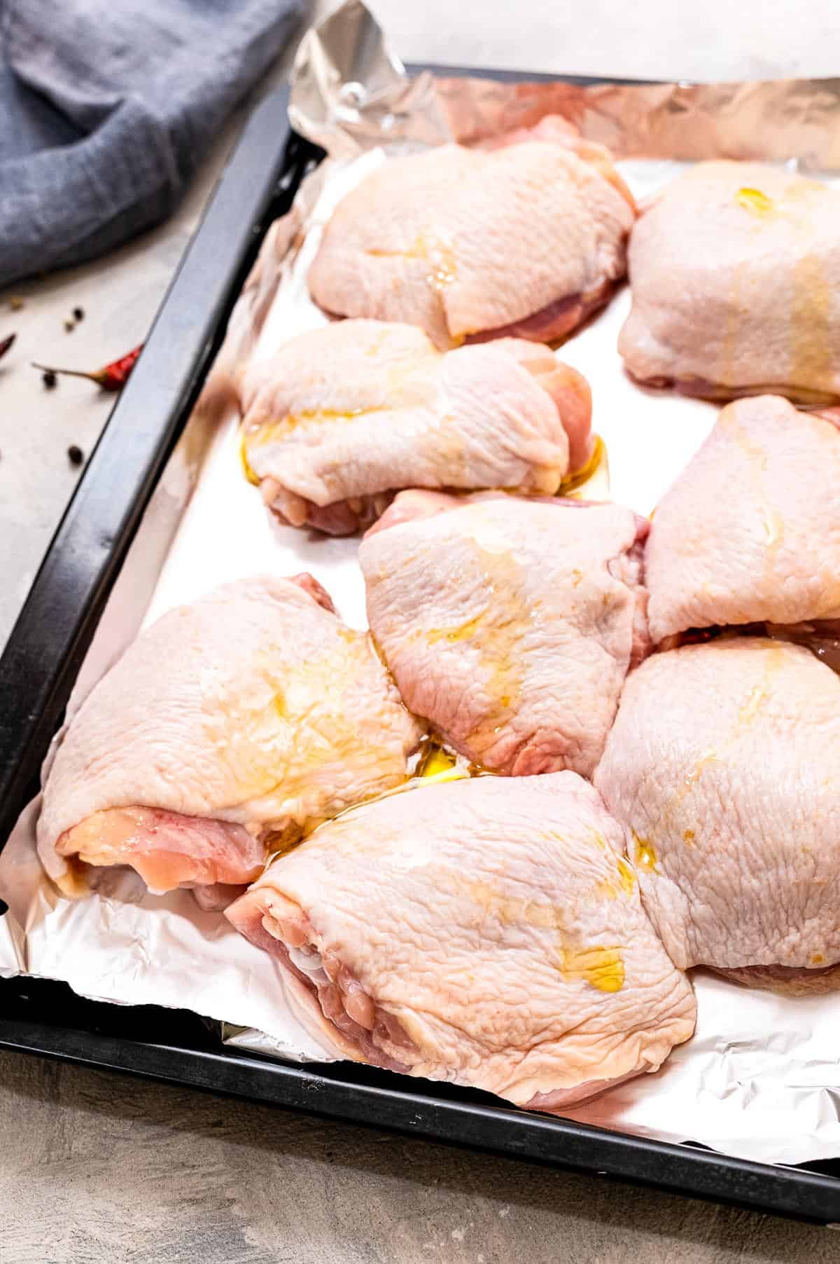 Sheet pan with chicken thighs on it