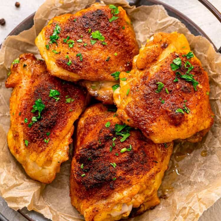 Four baked chicken thighs on platter
