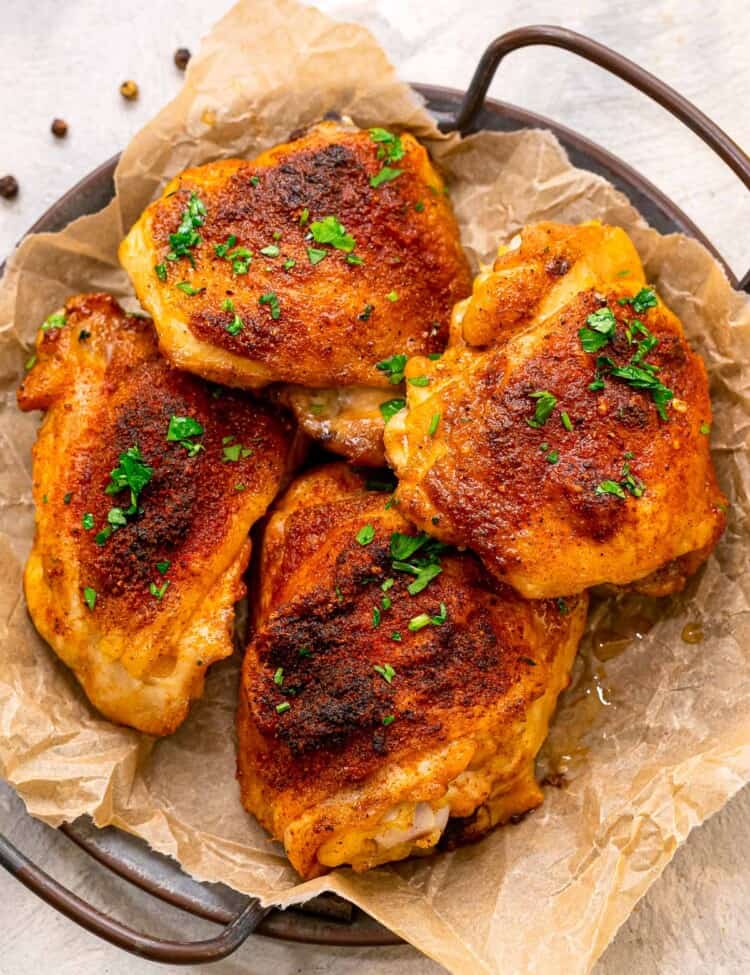 Four baked chicken thighs on platter