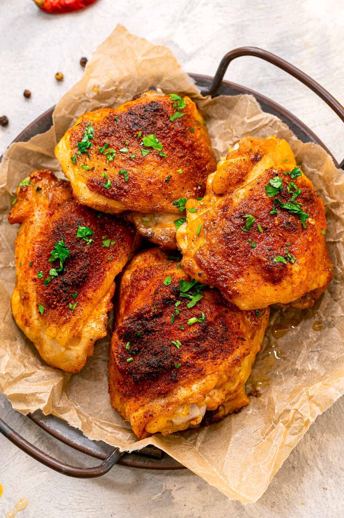 Four baked chicken thighs on platter