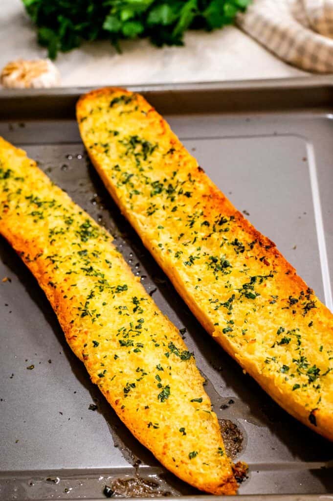 Two halves of French Bread baked with garlic butter on sheet pan