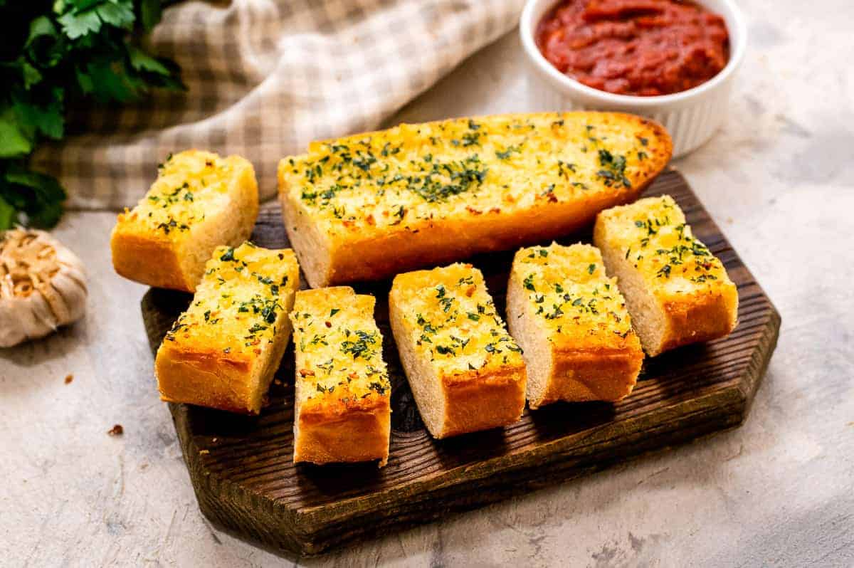 Homemade Garlic Bread pieces on a wood cutting board