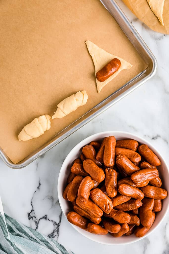 Rolling a cocktail Weiner in a crescent roll