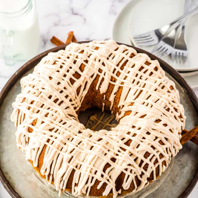 Pumpkin Bundt Cake with a drizzle of cream cheese frosting on cake stand