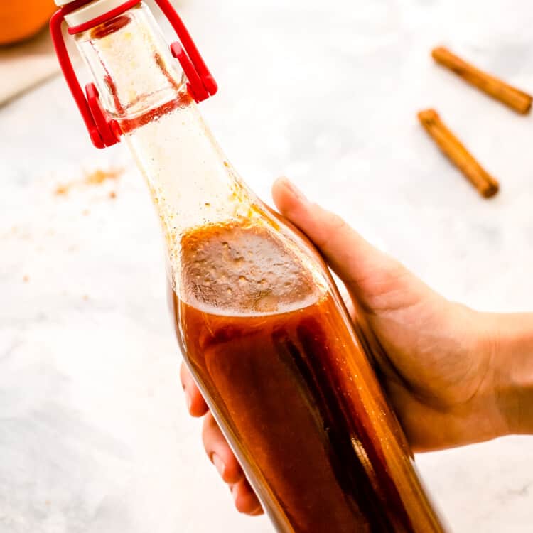 Hand holding glass bottle with pumpkin pie syrup in it