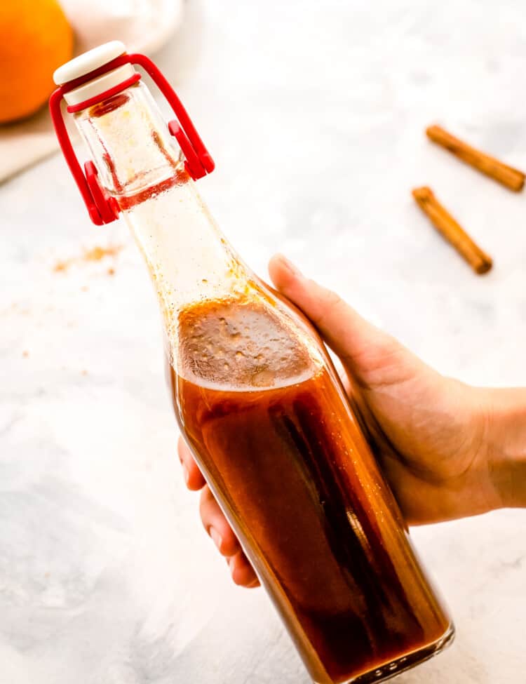 Hand holding glass bottle with pumpkin pie syrup in it