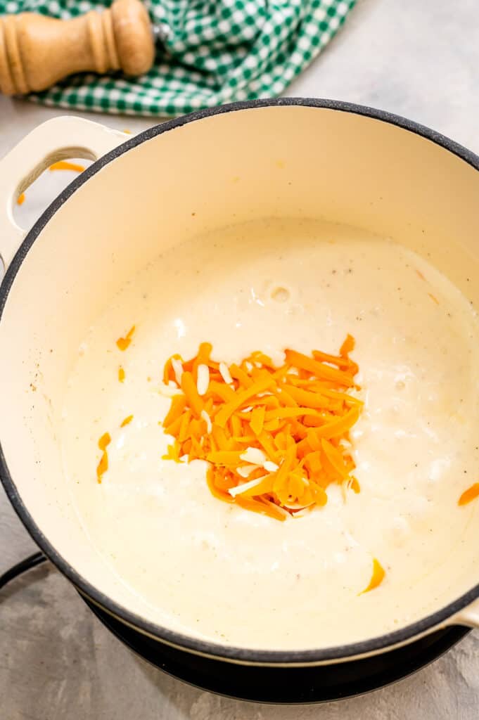 Dutch oven with cheese sauce being melted