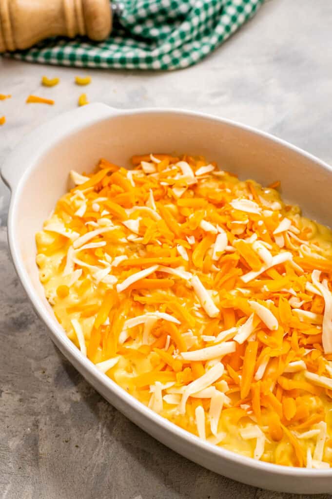 White casserole dish with shredded cheese in it