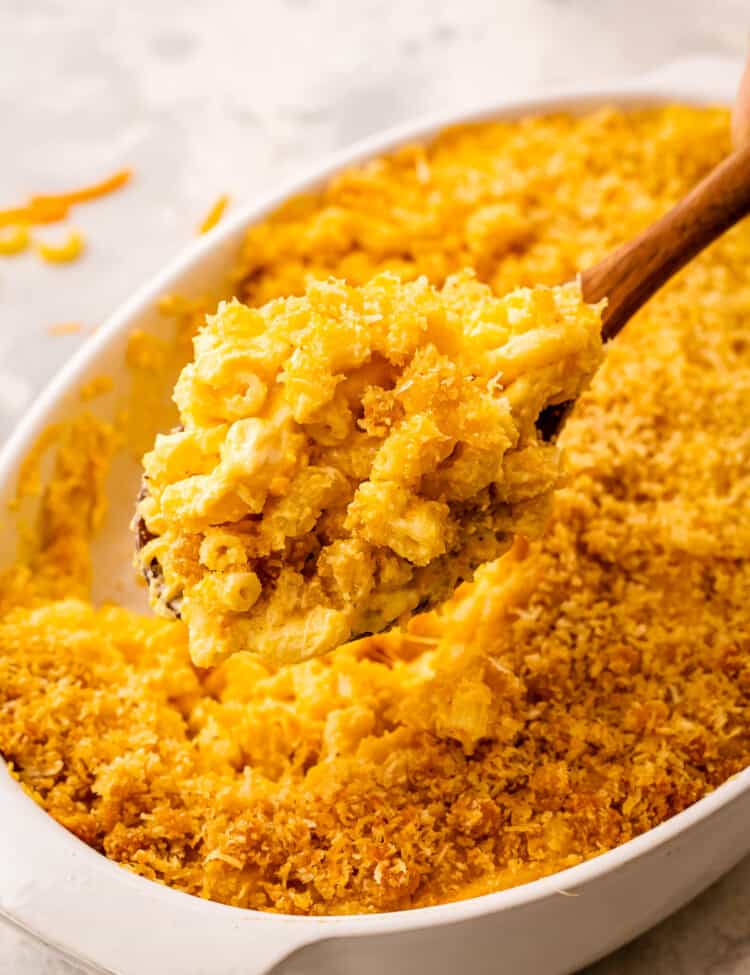 Spoon scooping mac and cheese out of casserole dish