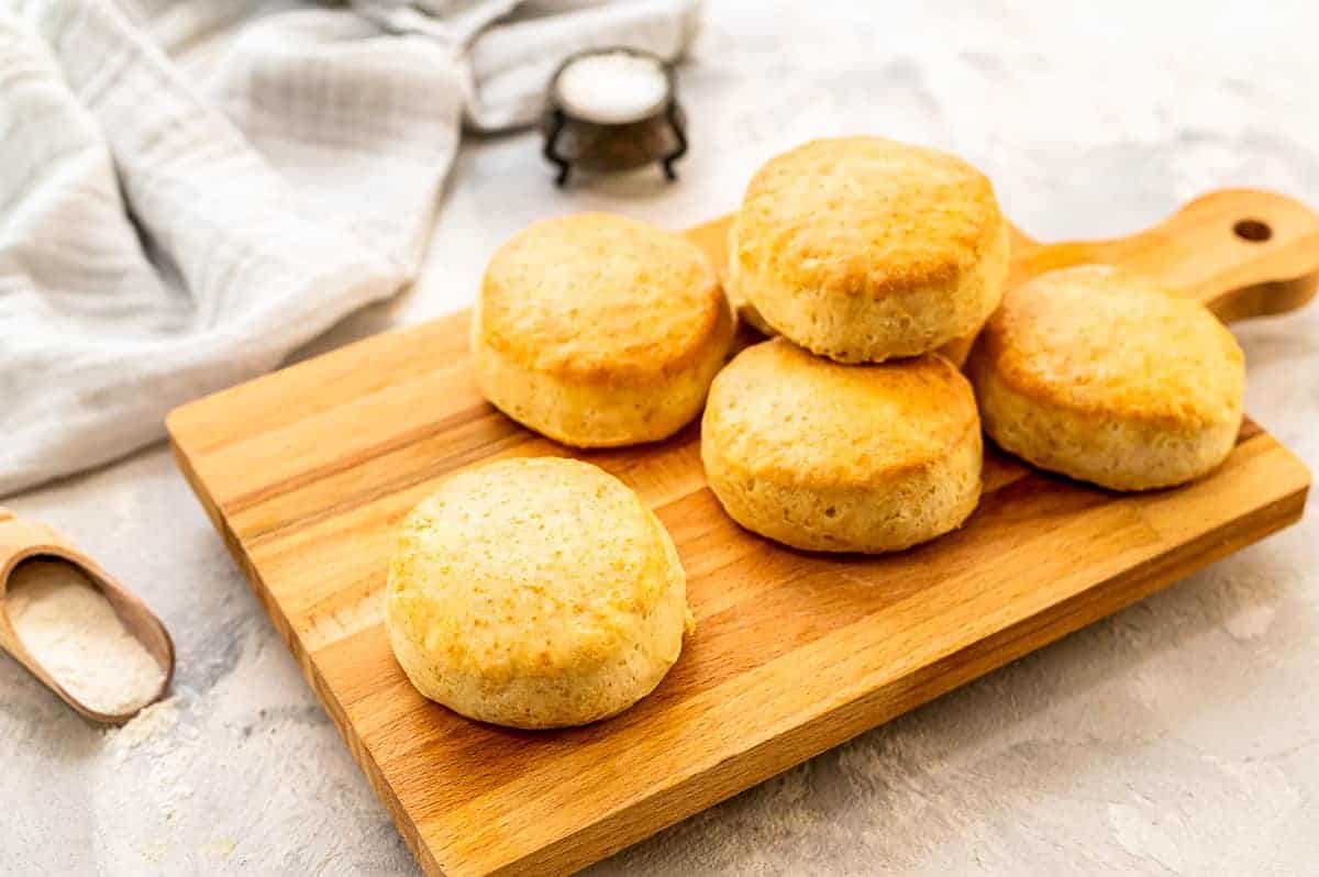 Rectangle cutting board with biscuits sitting on it