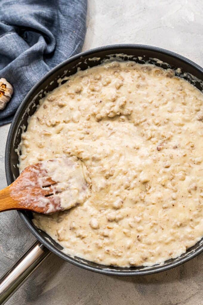 Skillet spoon stirring sausage gravy