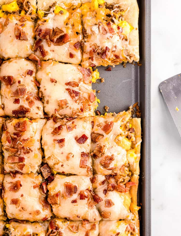 Overhead image of breakfast pizza in pan sliced