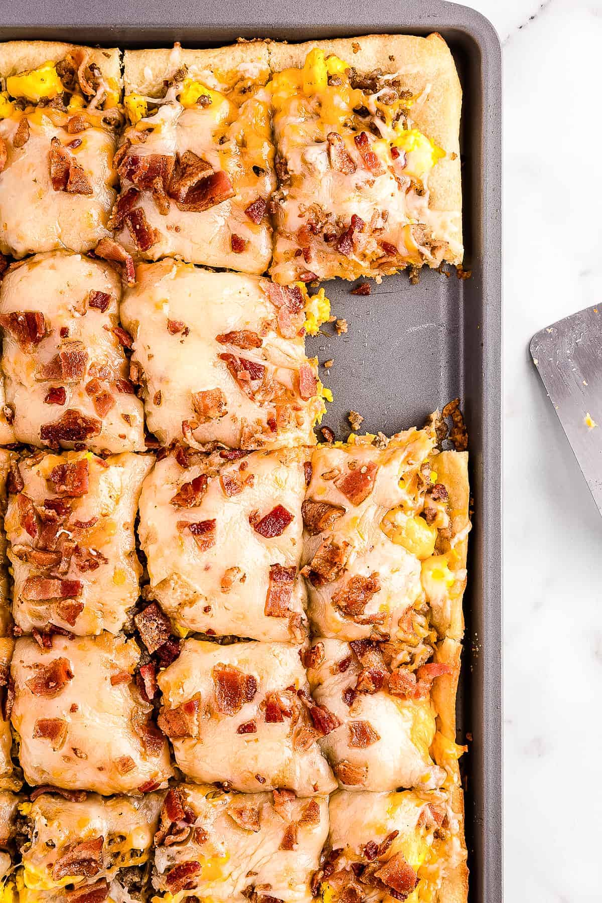 Overhead image of breakfast pizza in pan sliced