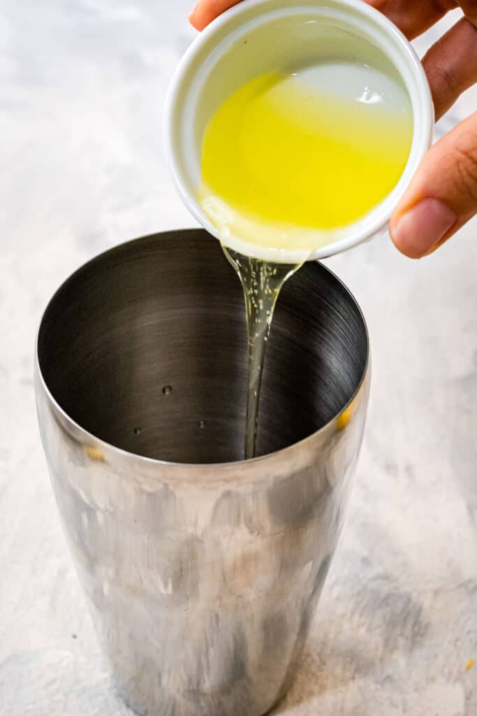 Pouring lemon juice into cocktail shaker