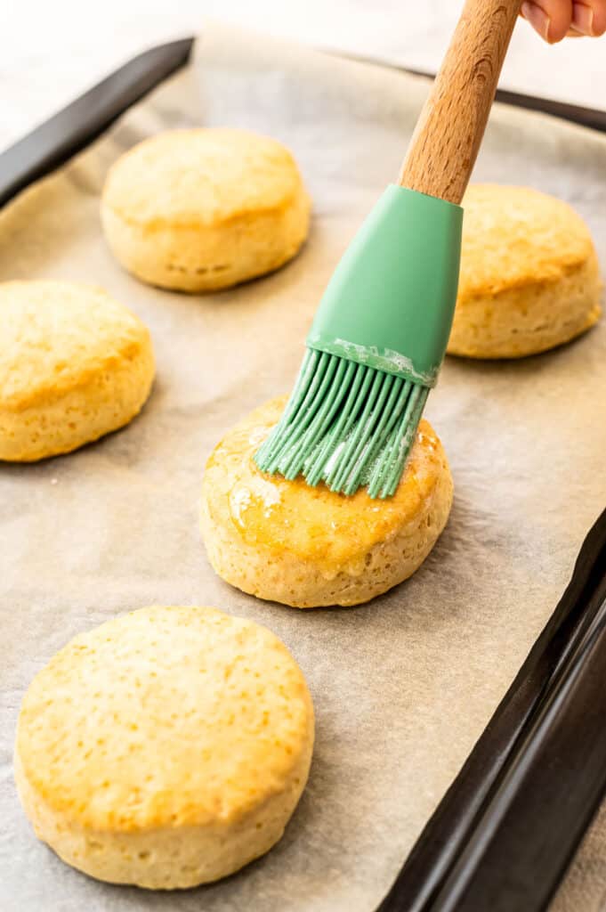 Brushing biscuit on sheet pan with butter