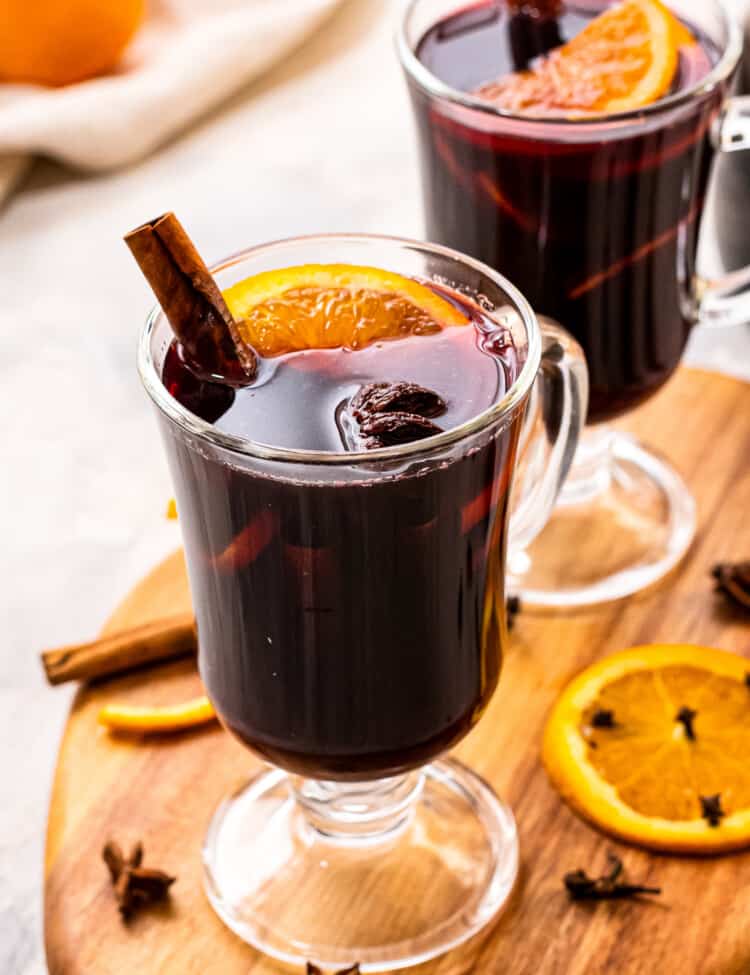 Tall glass mugs with mulled wine in them.