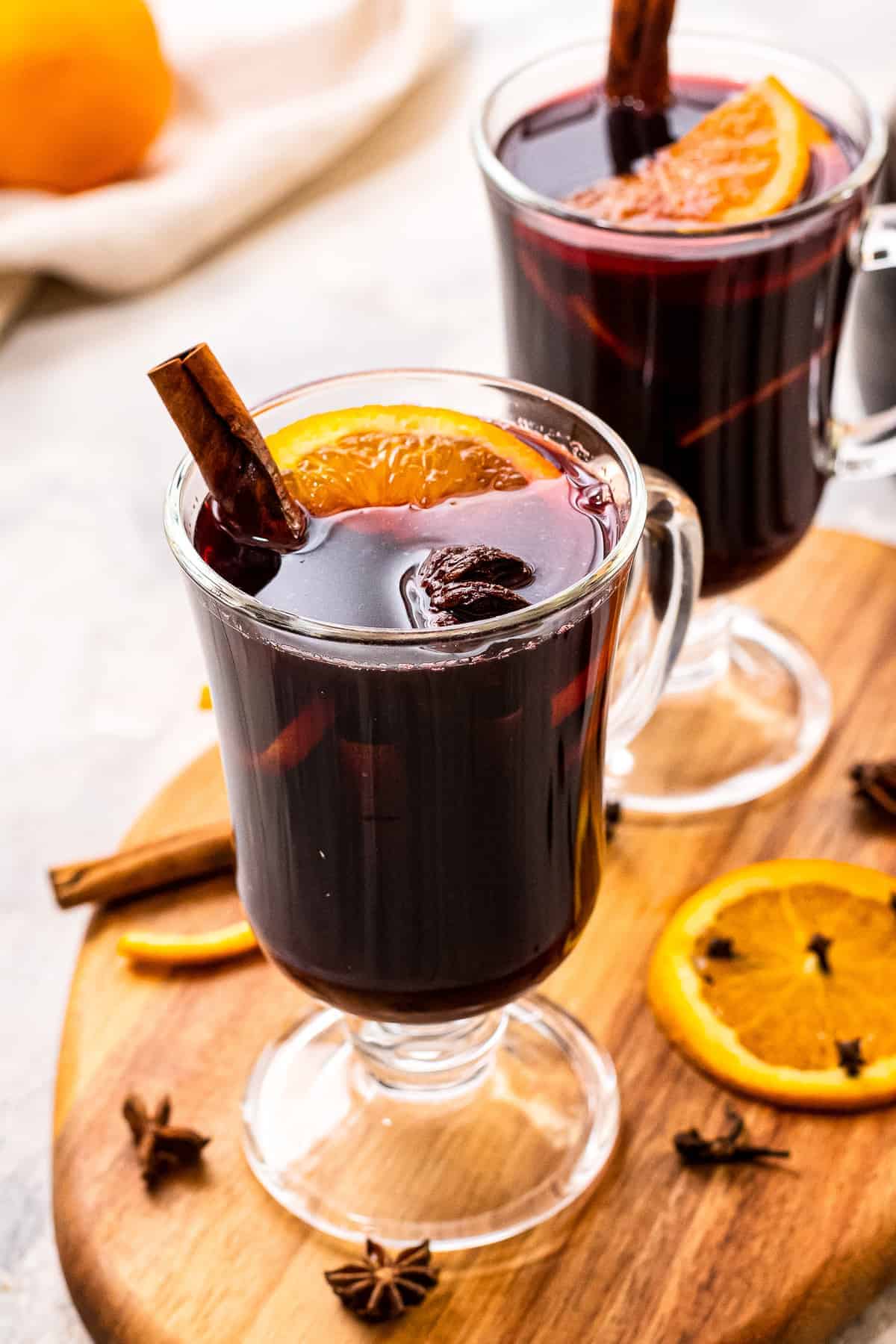 Tall glass mugs with mulled wine in them.