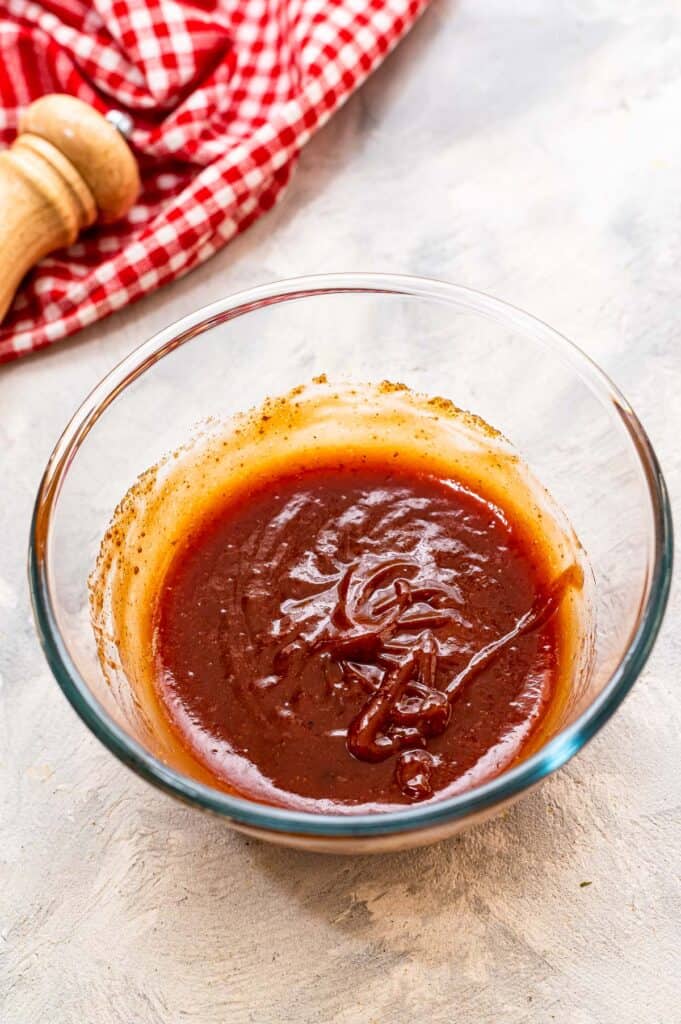 Brown sugar, mustard and ketchup mixed in glass bowl