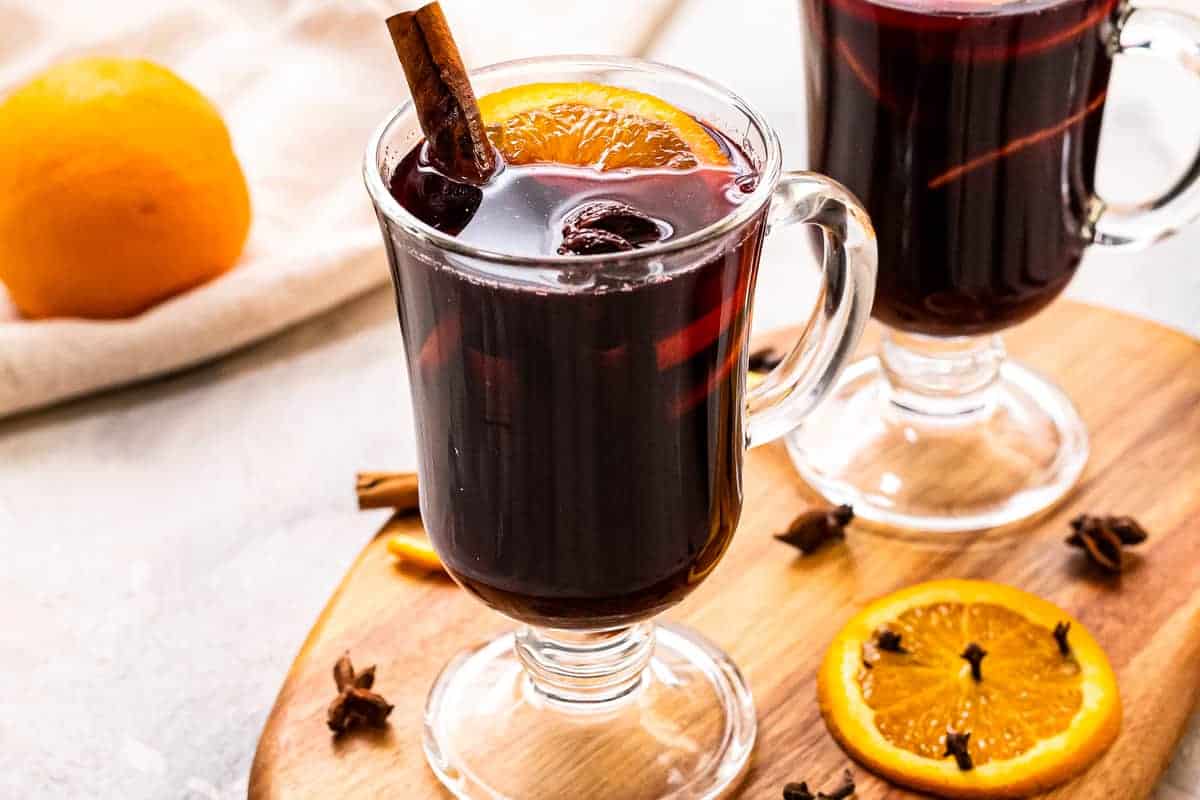 Glass mug of Mulled Wine garnished with orange slice and cinnamon stick