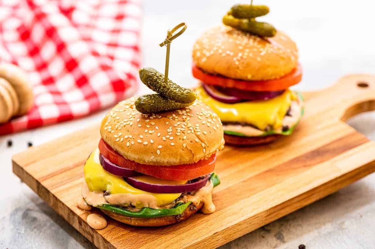 Wood cutting board with cheeseburgers on it