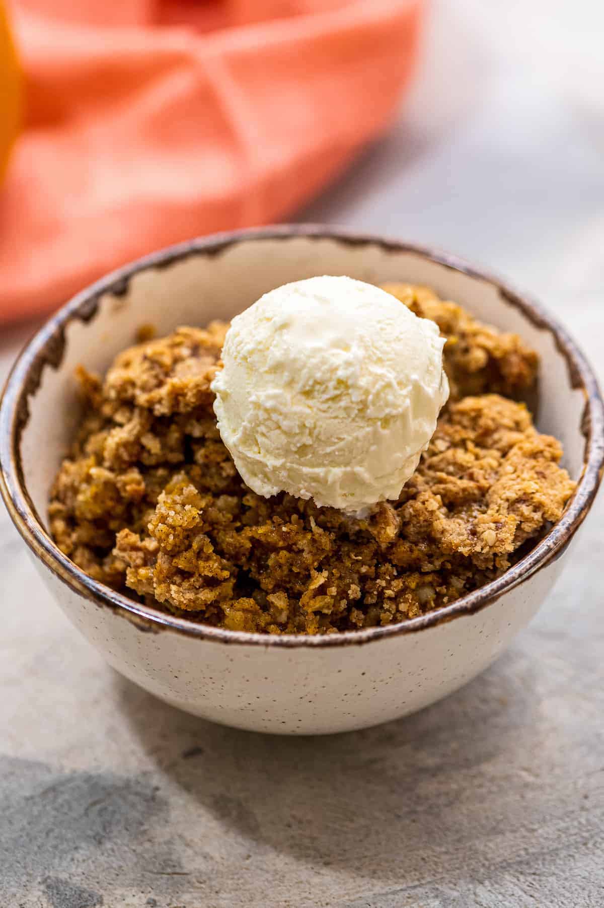 Scoop of Pumpkin Crisp in bowl with vanilla ice cream