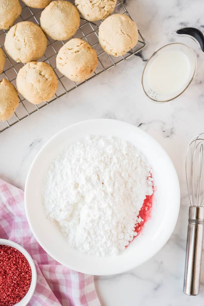 Powdered sugar in bowl with maraschino cherry juice to make frosting