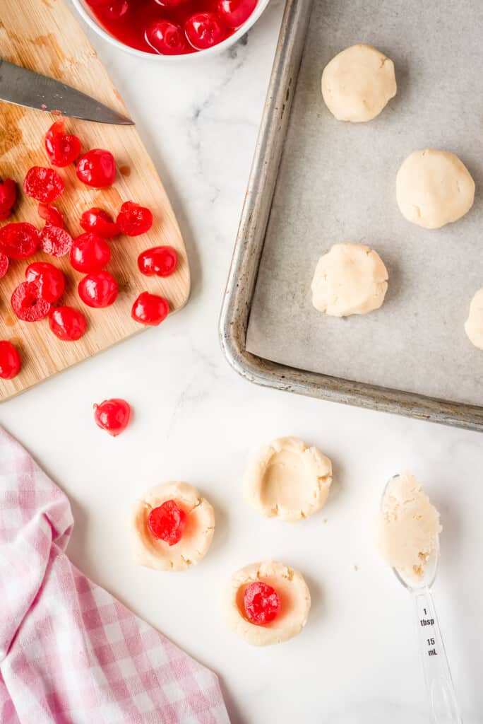 Putting a maraschino cherry in the middle of cookie dough