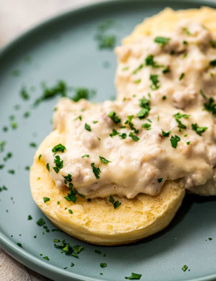 Split open biscuit topped with sausage gravy on plate