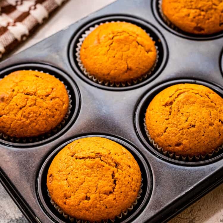Muffin tin with pumpkin muffins in it