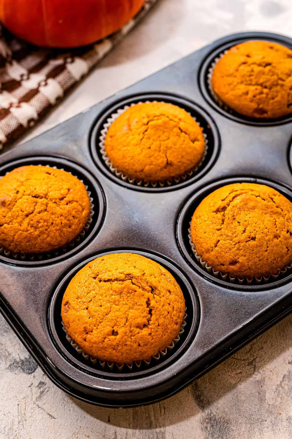 Muffin tin with pumpkin muffins in it