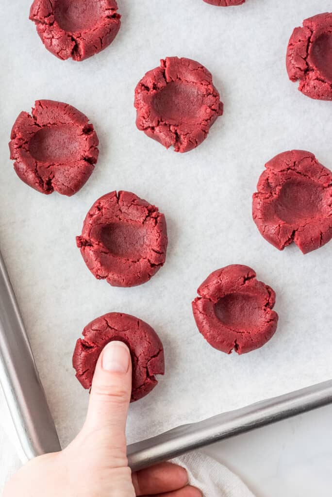 Thumb making indent in red velvet cookies