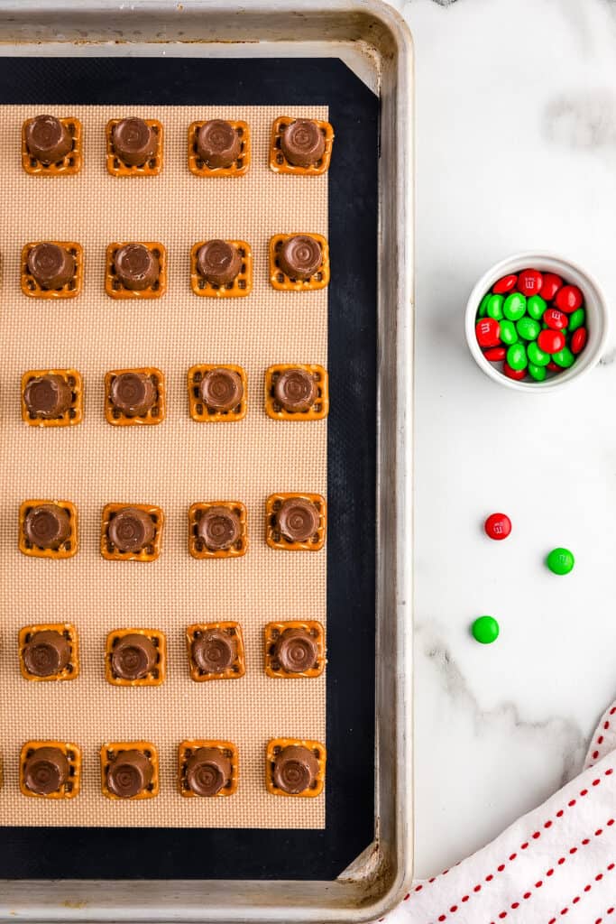 Overhead image of square pretzels and rolo on top of it on sheet pan