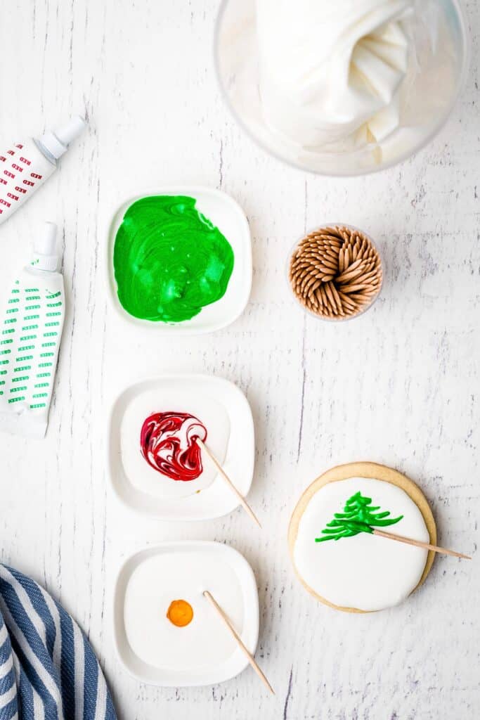 Showing how to make a christmas tree out of royal icing on sugar cookie