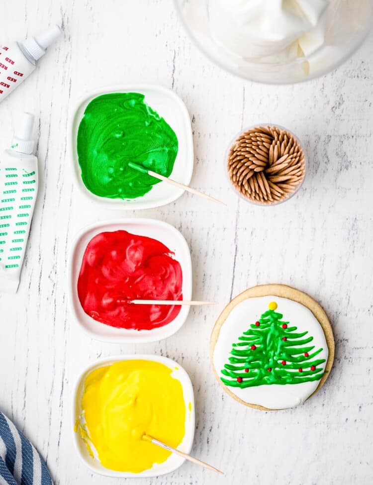 Overhead image of decorating Christmas sugar cookie with royal icing