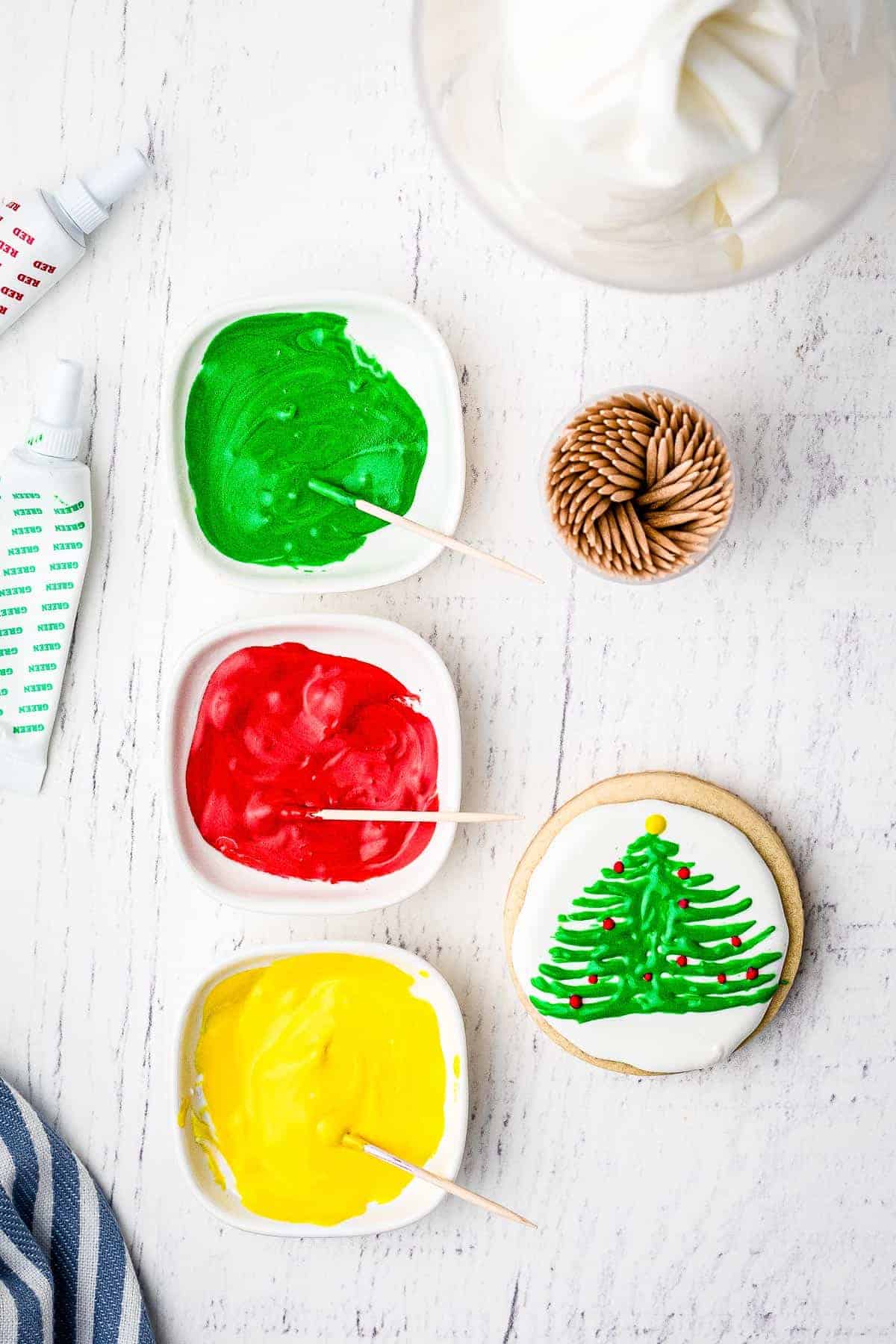 Overhead image of decorating Christmas sugar cookie with royal icing