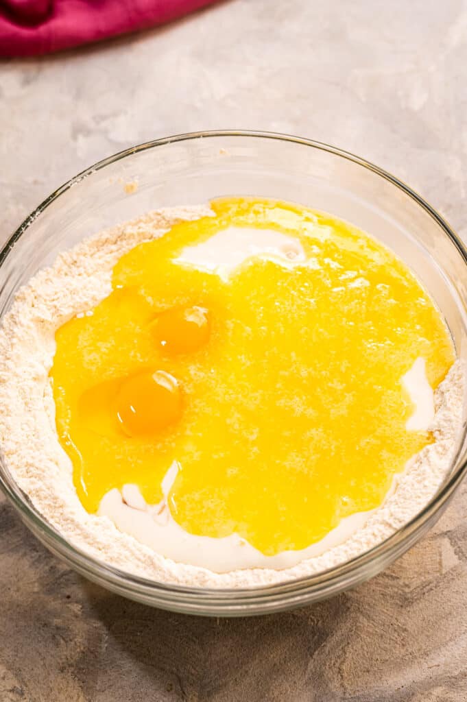 Eggs on top of dry ingredients in glass bowl