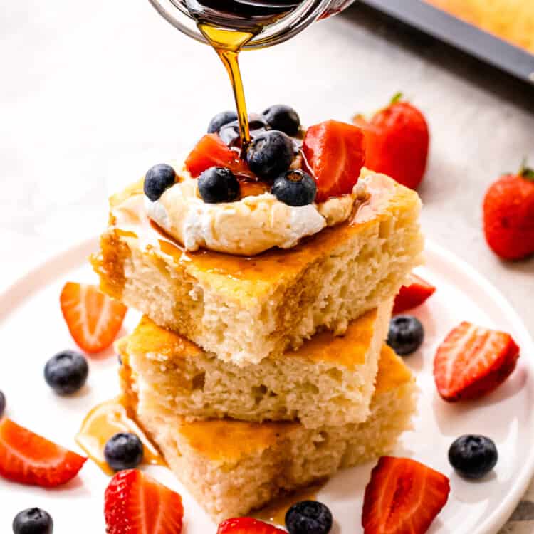 Pouring syrup over a stack of square pancakes