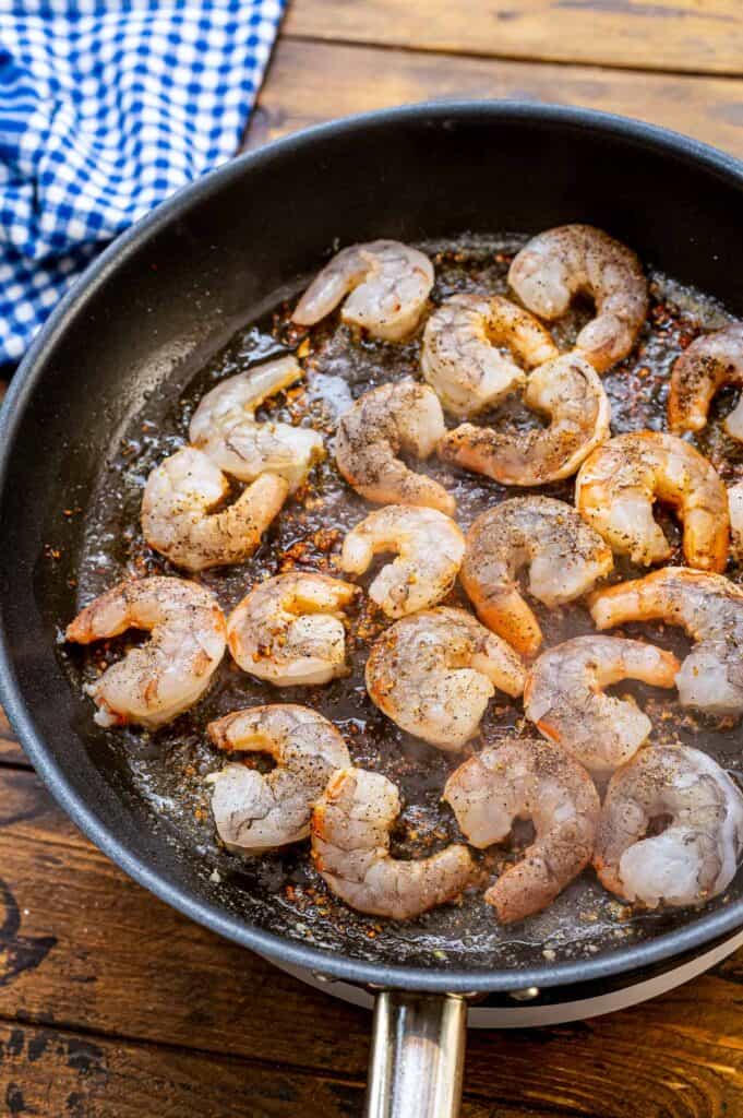 Skillet with shrimp sautéing in it