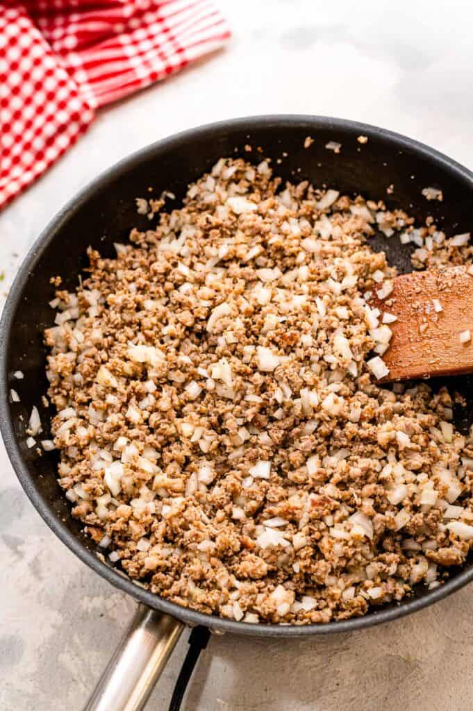 Skillet with Italian sausage and onions in it