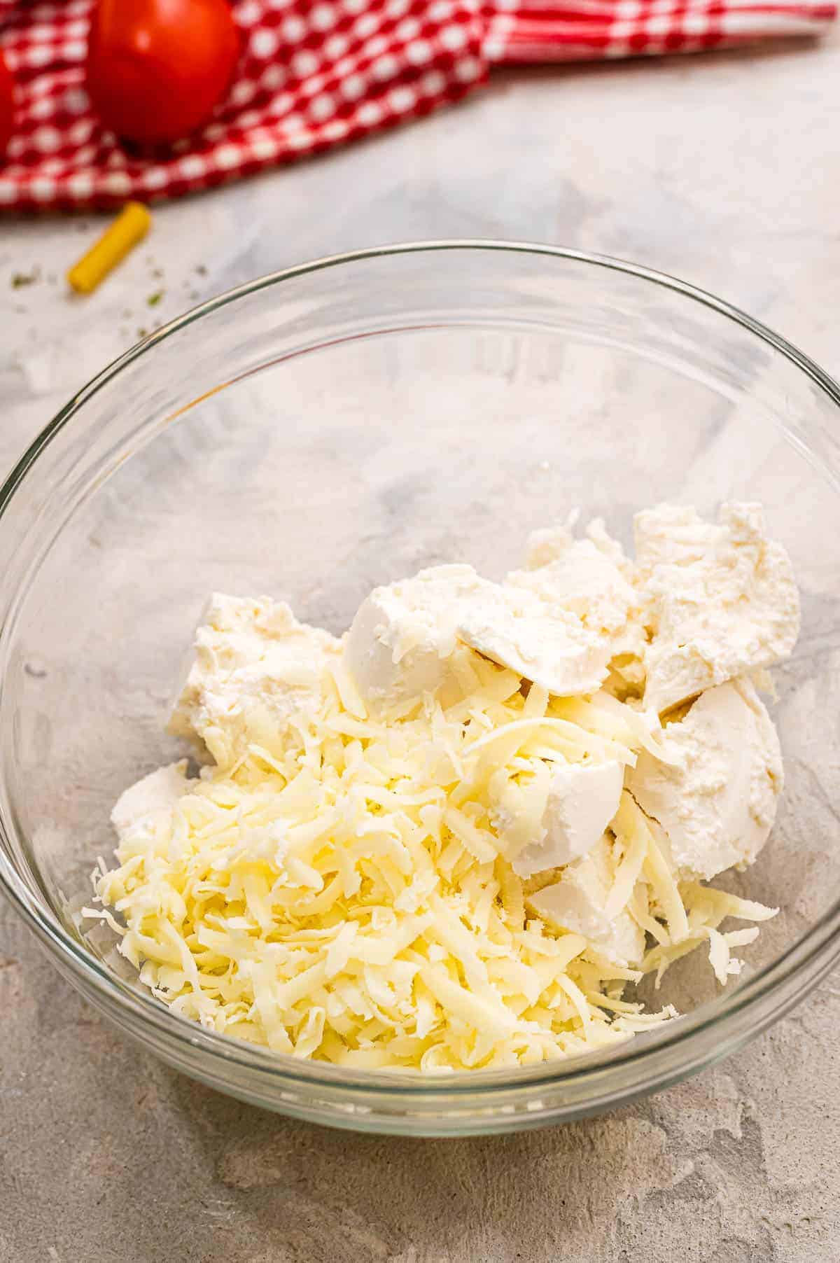 Glass bowl with shredded cheese and ricotta