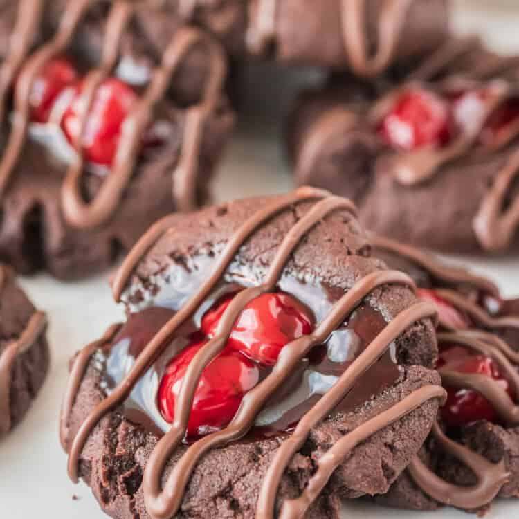 Chocolate Cherry Thumbprint Cookies with chocolate drizzle on white background