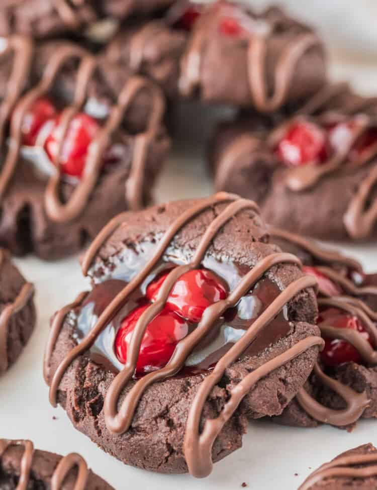 Chocolate Cherry Thumbprint Cookies with chocolate drizzle on white background