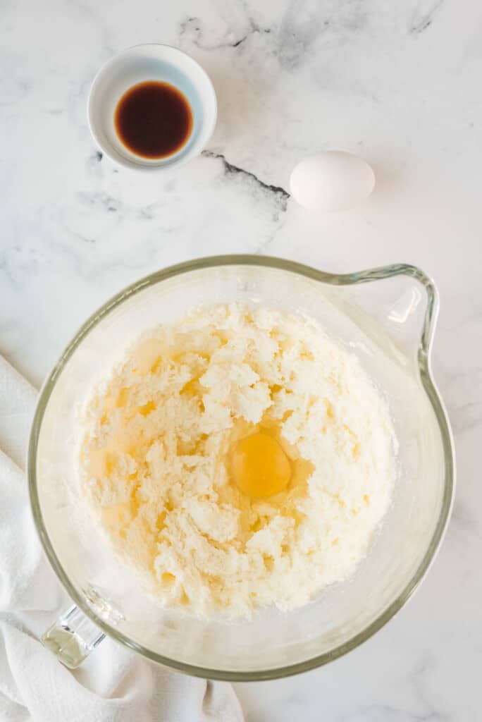 Glass bowl with stick of butter and white sugar creamed together and egg added