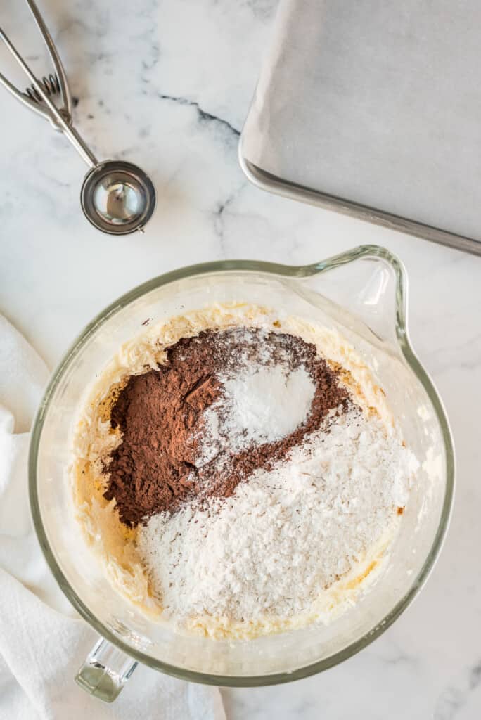 Glass bowl with stick of butter and white sugar with dry ingredients added