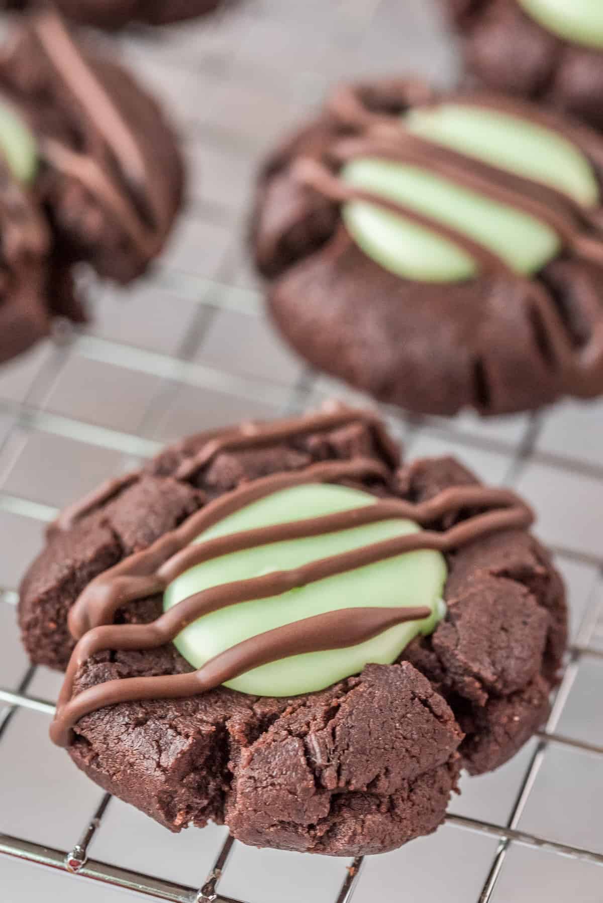 Chocolate Mint Thumbprint Cookie on wire rack with chocolate drizzle