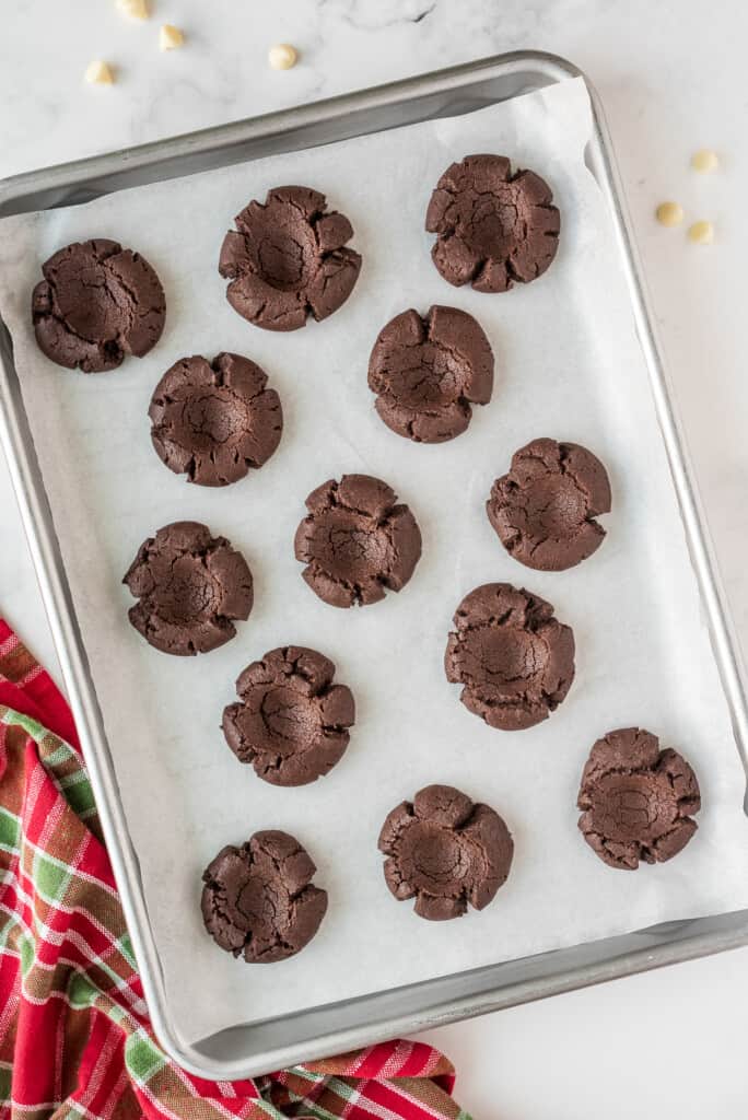 Baking sheet with baked chocolate thumbprint cookie